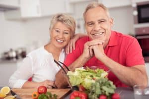 Ein Mann und eine Frau freuen sich über ihren frisch gemachten Salat
