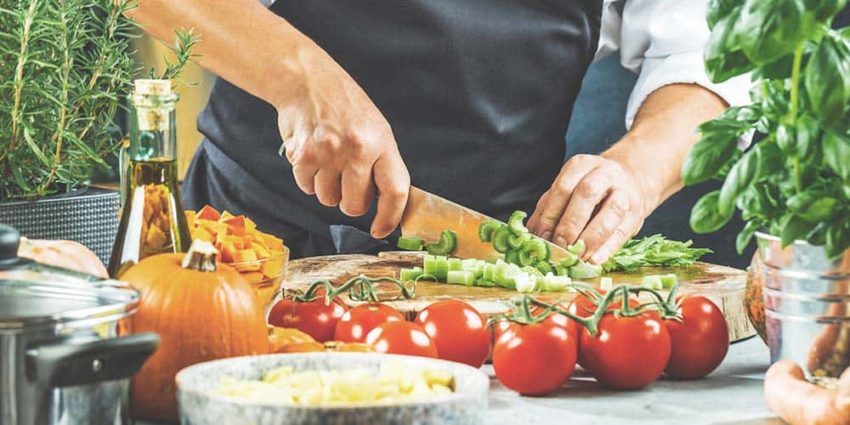 Koch schneidet Gemüse für eine Mahlzeit klein