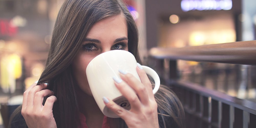 Junge Frau trinkt Tee aus einer Tasse